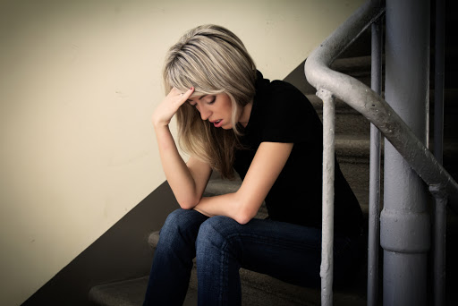 Young unhappy woman in depression sitting on stairs &#8211; pt