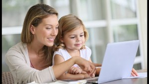 Little girl looking at laptop computer with her mom © Goodluz / Shutterstock – pt