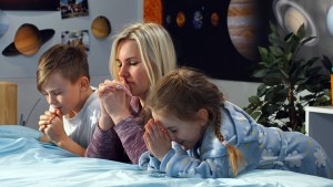 Mãe e filhos rezando
