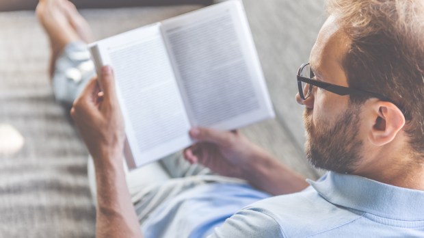 Homem concentrado lendo um livro