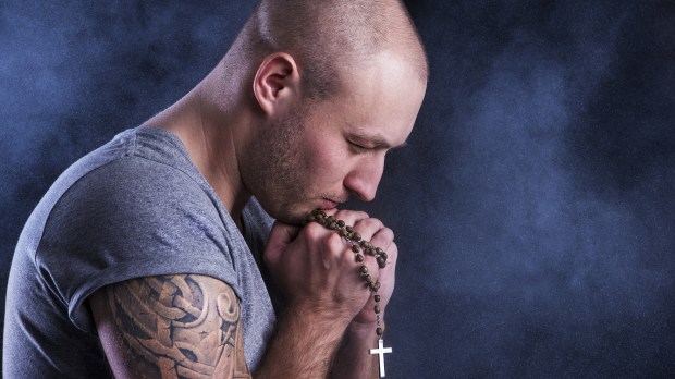 Handsome young man with tattoo isolated on black