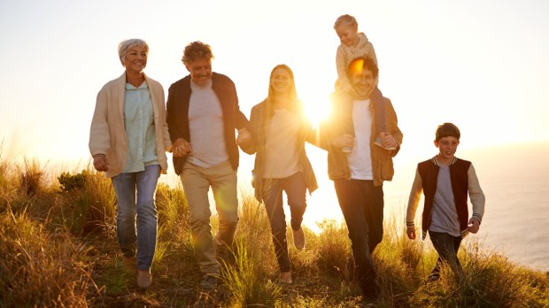 Multigenerational family walking together at sunset