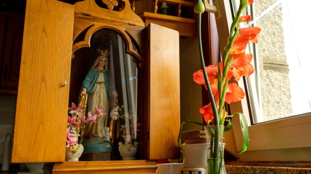 imagen de una virgen colocada en un altar de madera con una tapa para llevar de una casa a otra
